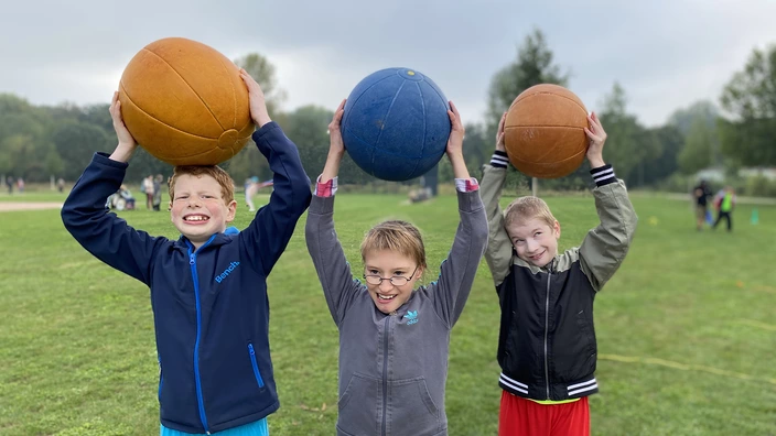 Drei Kinder mit Medizinbällen