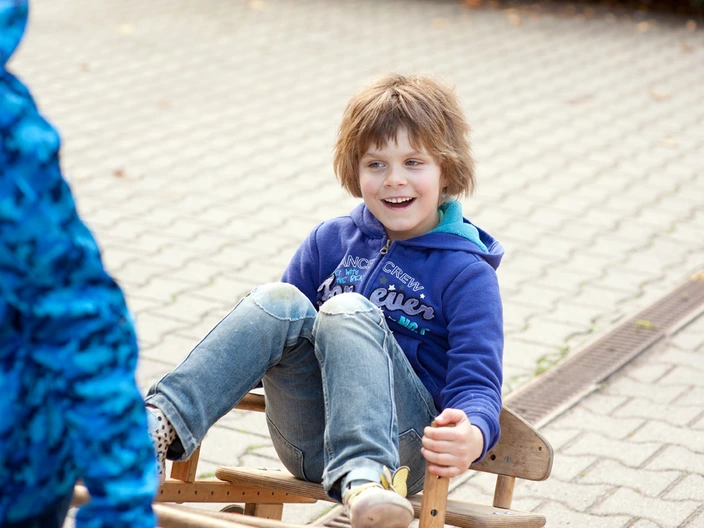 Schülerin auf einem Spielgerät auf dem Schulhof